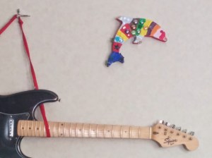 Broken guitar I'm going to take apart, and a craft my son made when he was younger. There is a place near our house called Whimsy, where kids can do various types of art, and when he was little there were a lot of birthday parties there. We have a lot of painted dolphins, my son's equivalent of Kandinsky's rider.